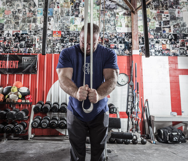 Man exercising with resistance bands in a gym setting